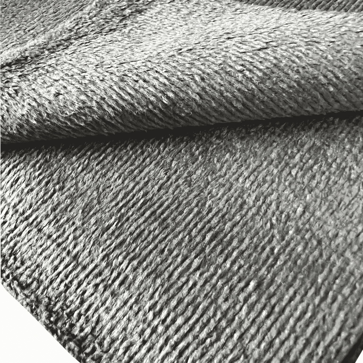 Gros plan sur les fibres courtes d’une microfibre grise polyvalente pour le detailing